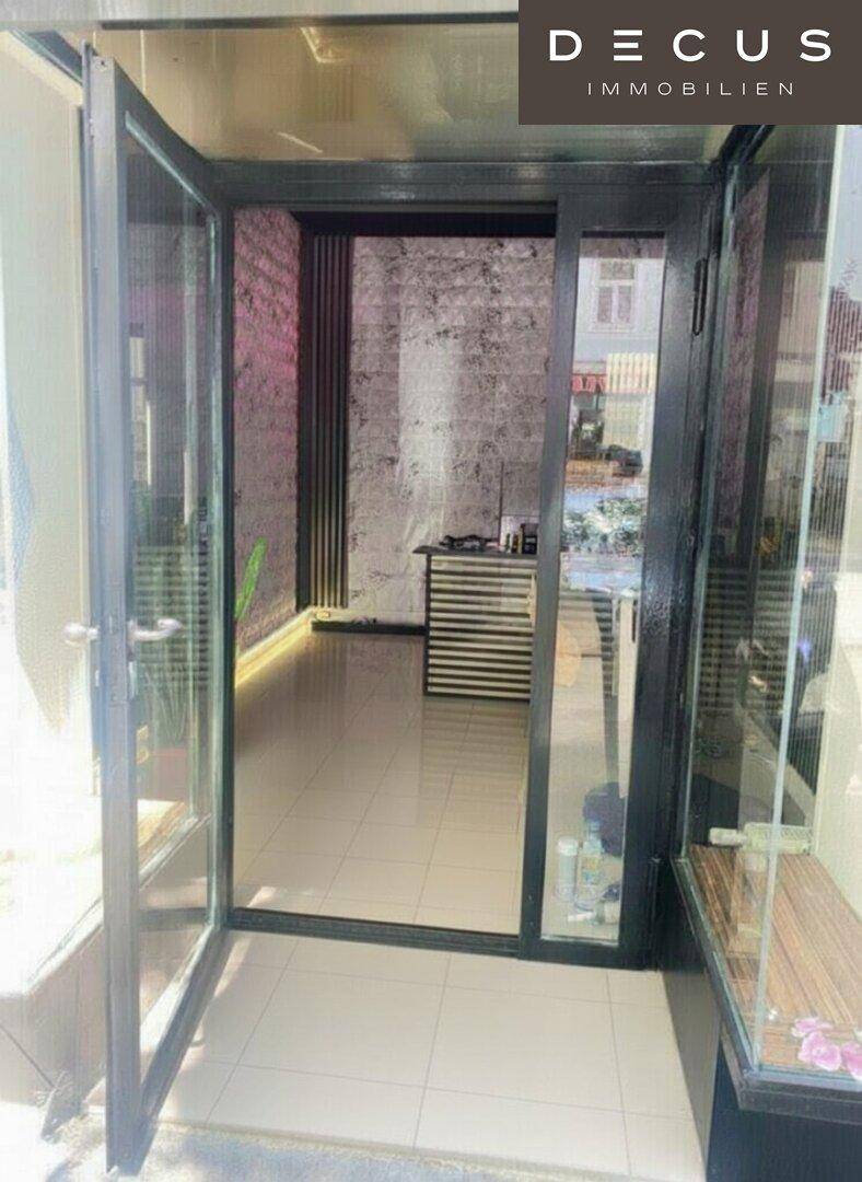 Heller Eingangsbereich mit Glasfront und modernem Design, einladend und offen.