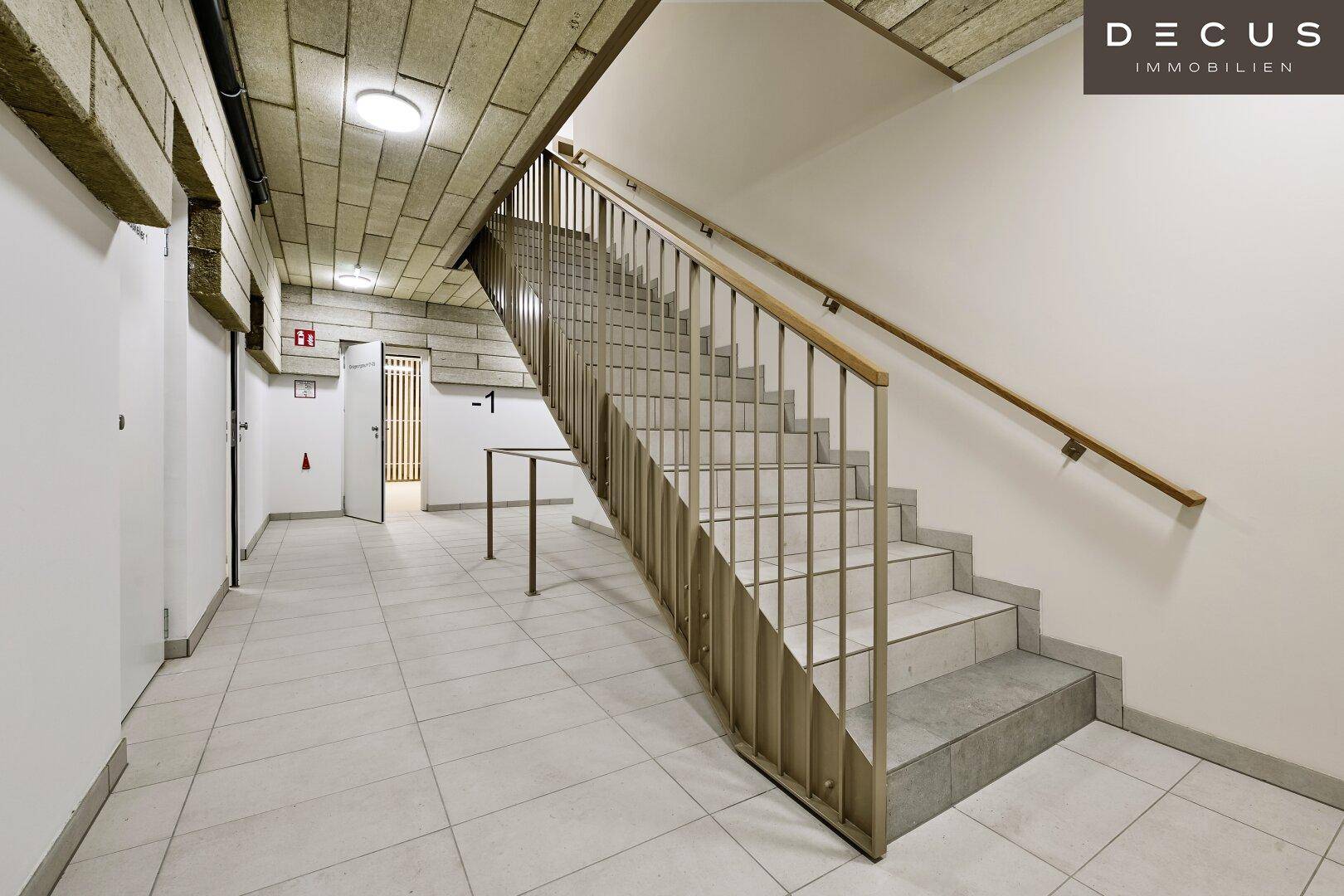 Treppenhaus im Untergeschoss mit Fliesenboden und Zugang zu weiteren Räumen.
