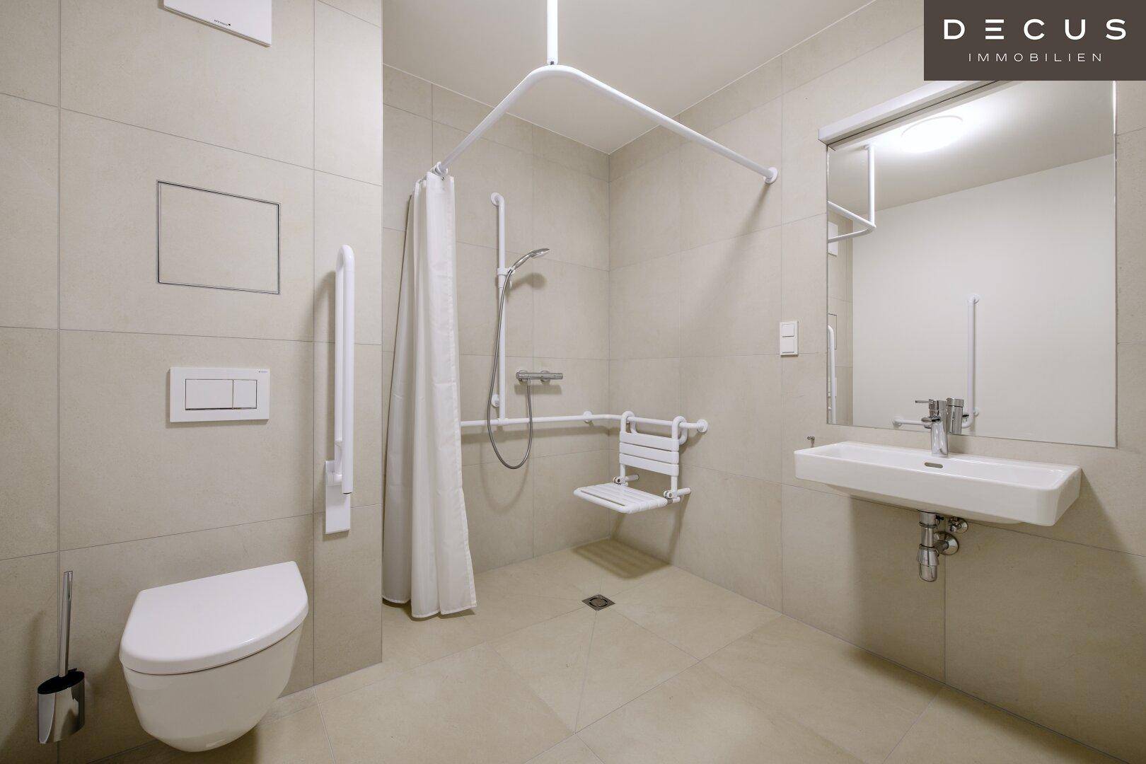 Barrierefreies Badezimmer mit ebenerdiger Dusche, Haltegriffen und wandhängendem WC.