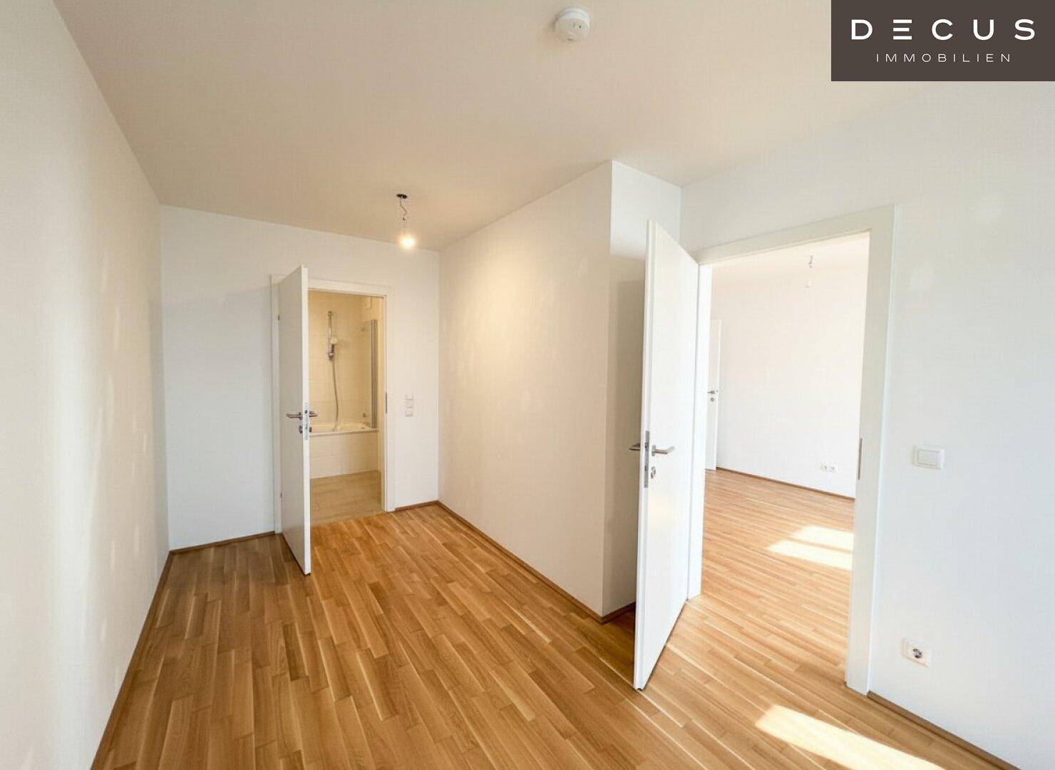 Heller Flur mit Parkettboden und Türen zu angrenzenden Räumen, inklusive Badezimmer.