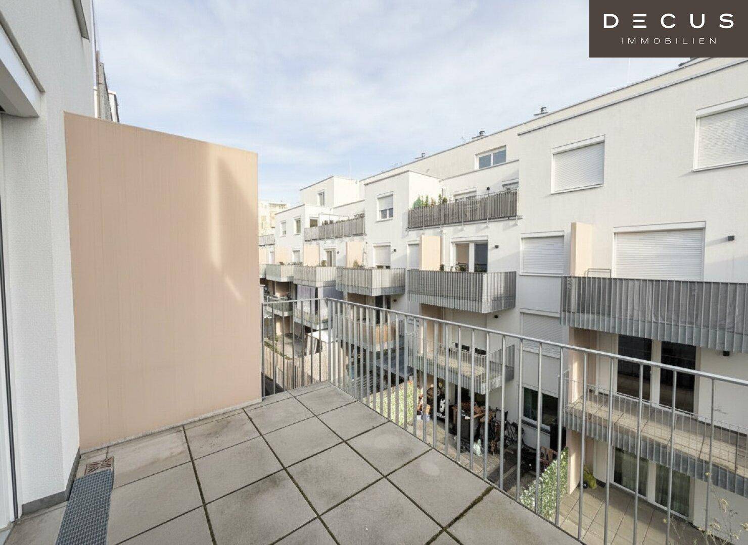 Geräumiger Balkon mit Fliesenboden und Blick auf die umliegenden Wohngebäude.