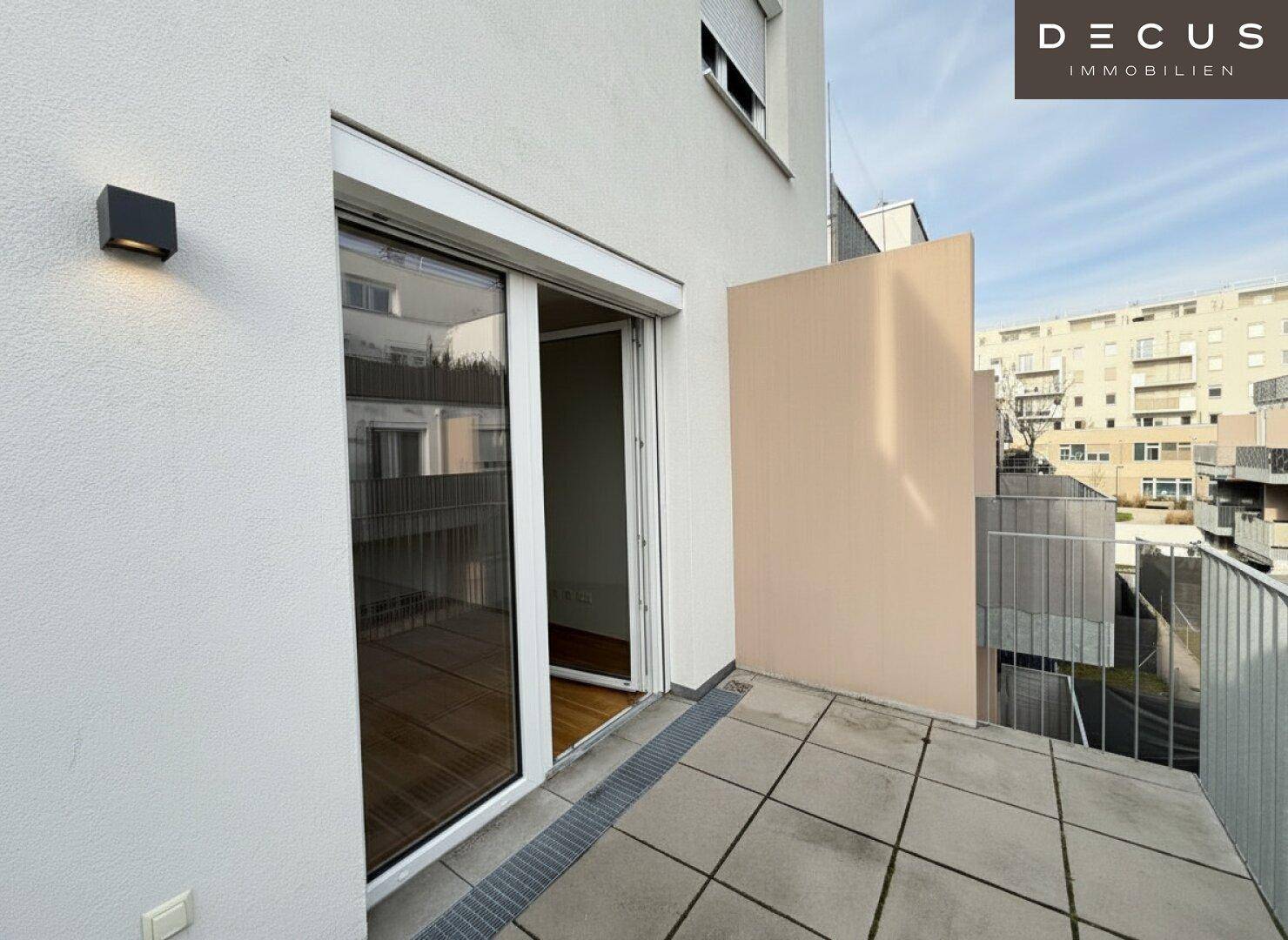 Heller Balkon mit Fliesenboden und Schiebetür, ideal für entspannte Stunden im Freien.