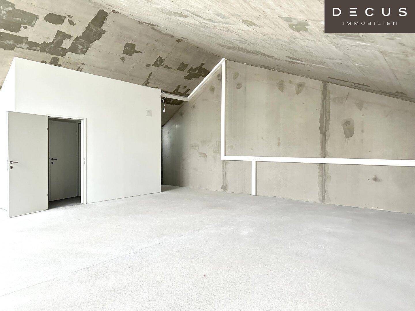Offener Rohbau-Raum mit Sichtbetondecke, weißen Wänden und viel Potenzial für individuelle Gestaltung.