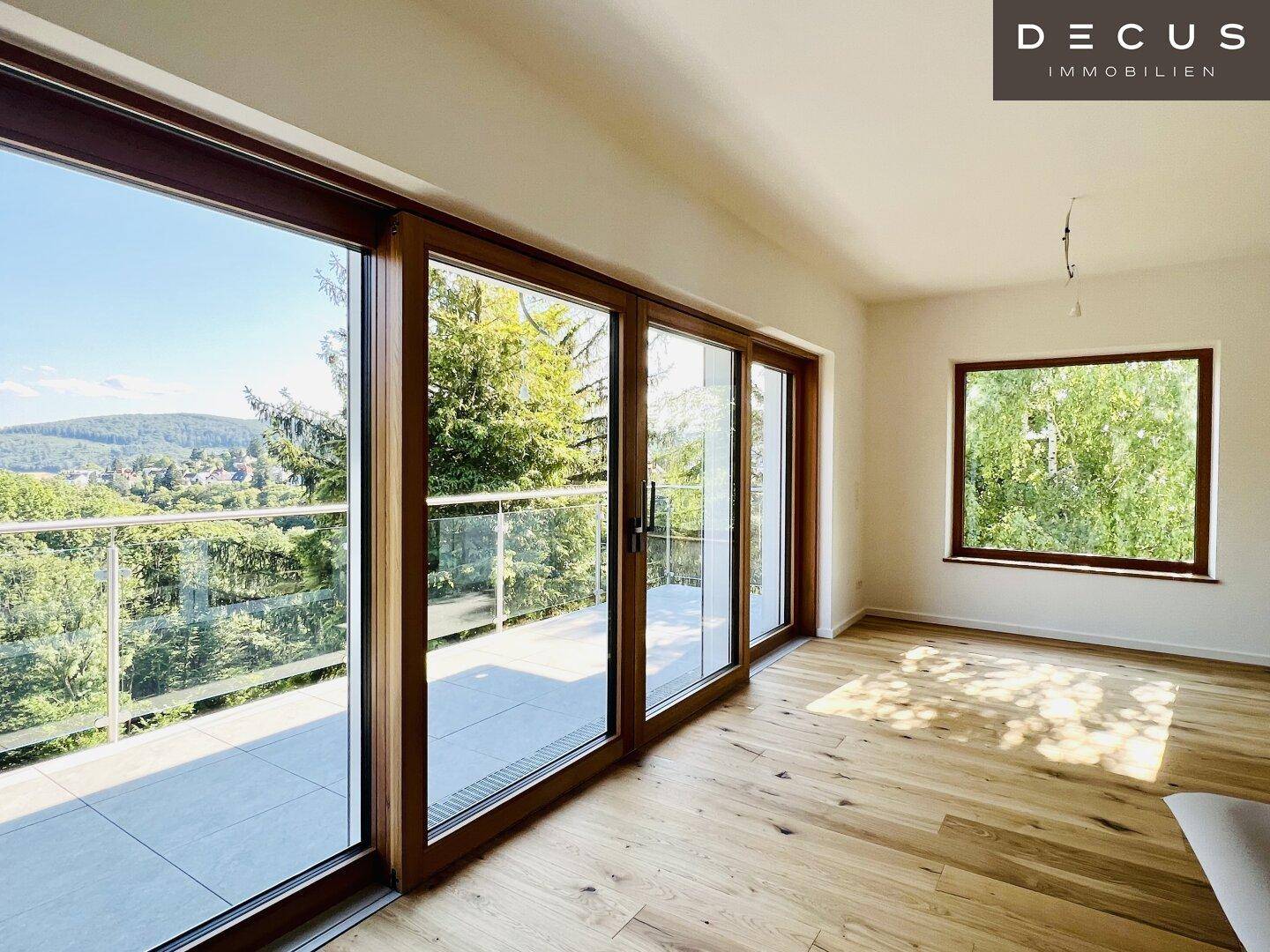 Helles Zimmer mit großen Schiebetüren, Holzboden und weitem Blick ins Grüne.