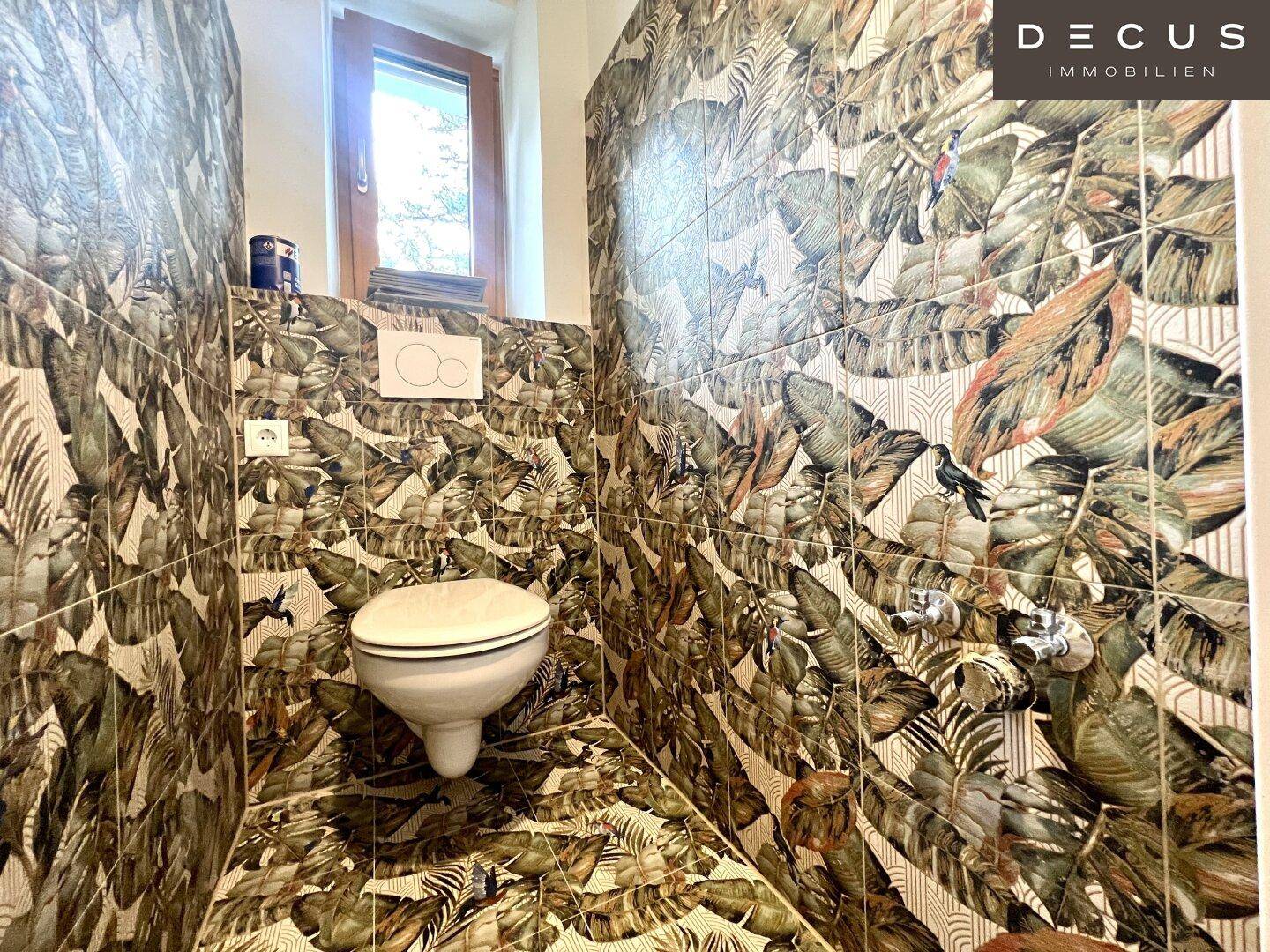 Modernes Gäste-WC mit auffälligen tropischen Blättermustertapeten und Fenster.