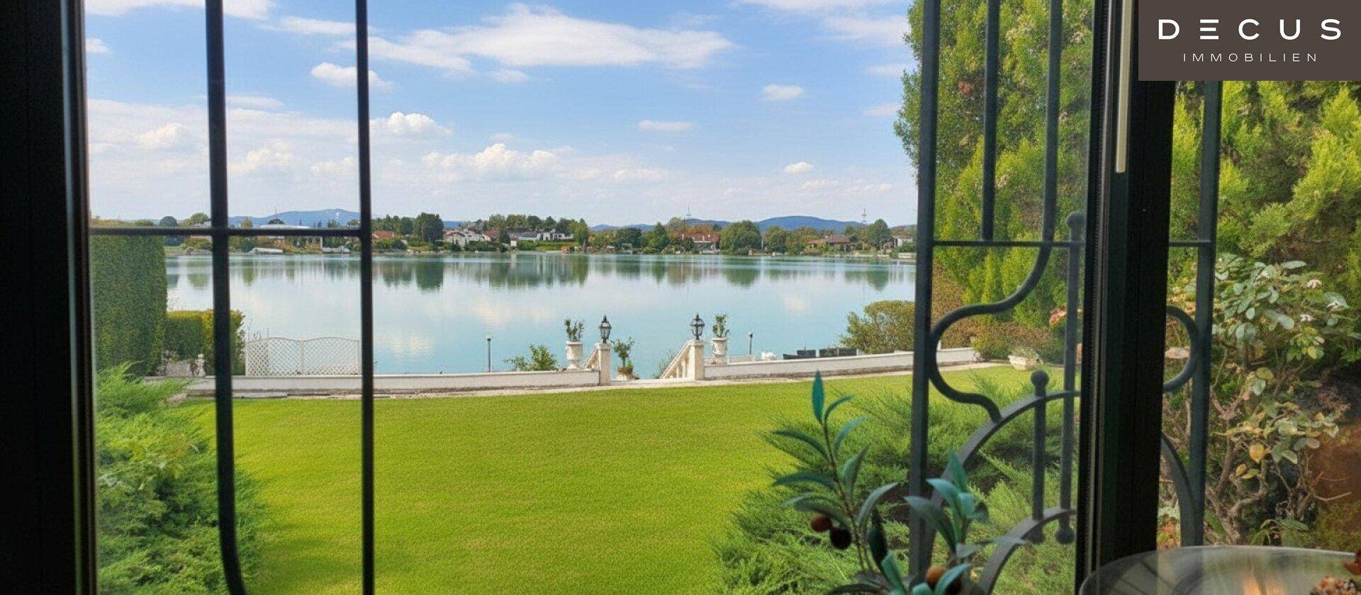 Weitläufiger Seeblick und grüne Landschaft durch die Fenster des Anwesens.