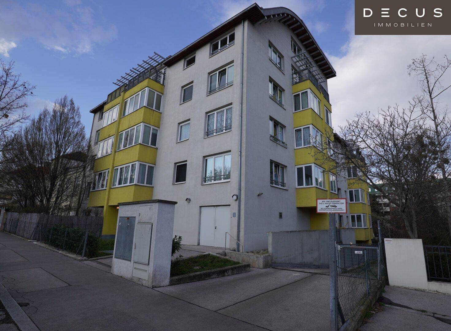 Moderne Wohnhausfassade mit gelben Balkonen und großen Fenstern.