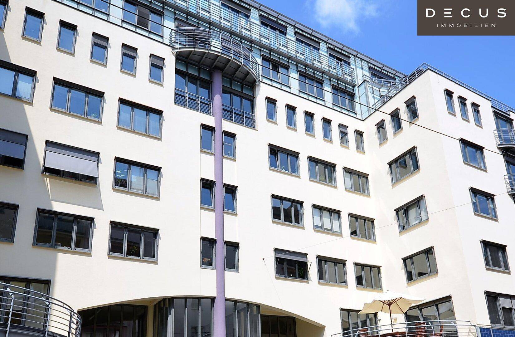 Moderne Gebäudefassade mit vielen Fenstern, Balkonen und einer ansprechenden Architektur unter klarem Himmel.