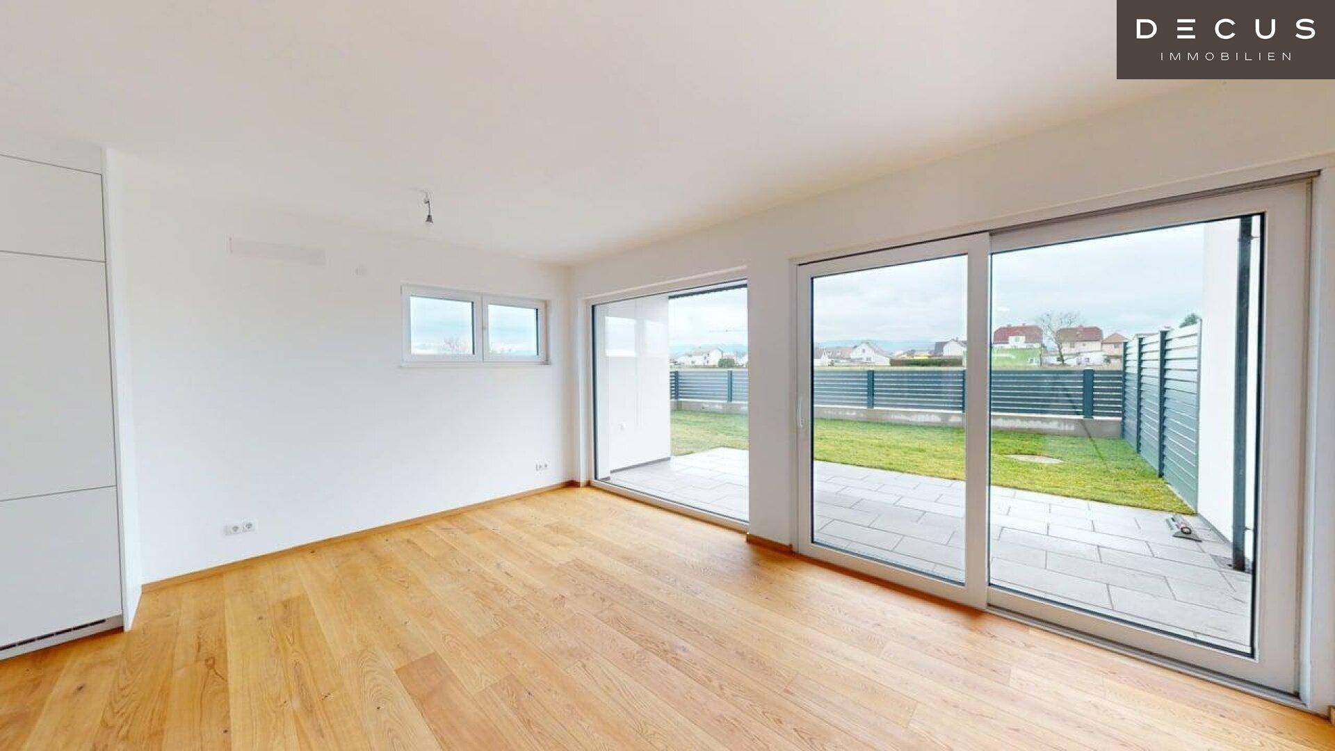 Heller Wohnbereich mit großen Schiebetüren, die Zugang zur Terrasse und zum Garten bieten.