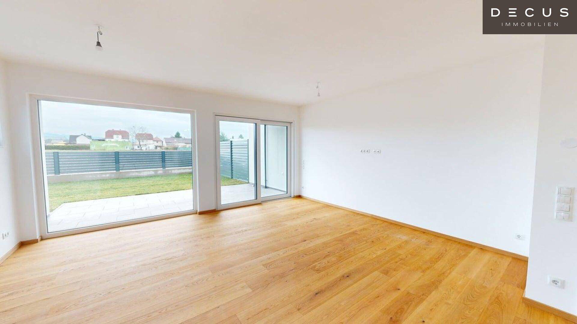 Lichtdurchfluteter Wohnbereich mit großen Fensterfronten und direktem Zugang zum Außenbereich.