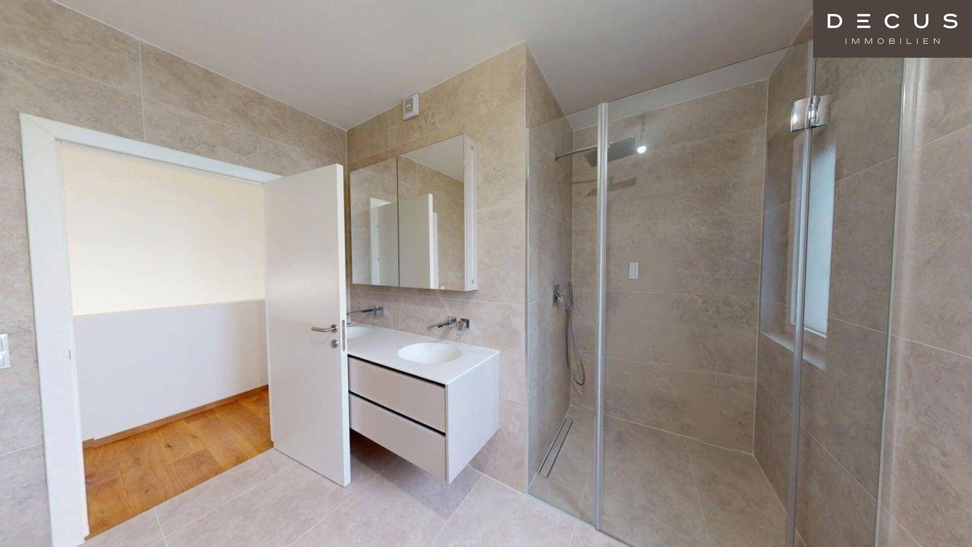 Modernes Badezimmer mit begehbarer Dusche, Einzelwaschbecken und hellen Fliesen.