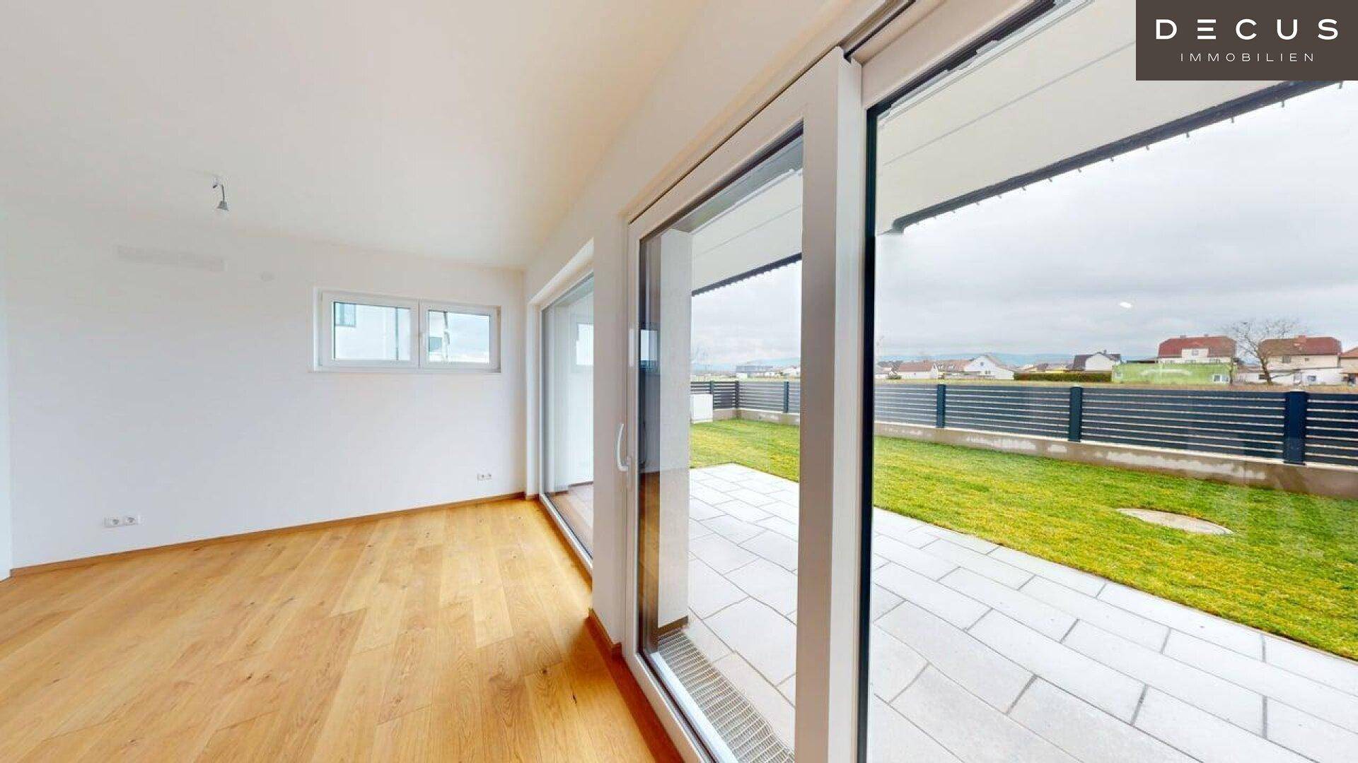 Heller Wohnbereich mit großen Schiebetüren, die den Blick auf den Garten freigeben.