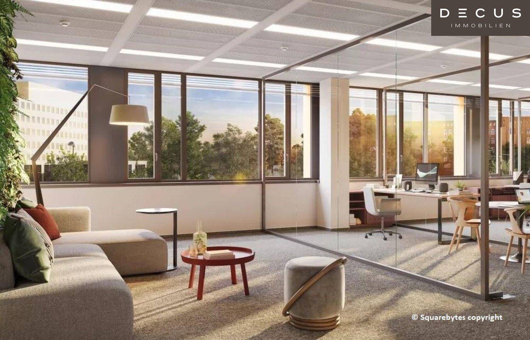 Gemütlicher Loungebereich in einem modernen Büro mit bequemen Sofas und großen Fenstern mit Blick ins Grüne.