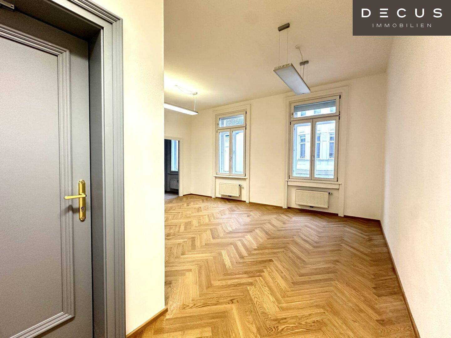 Heller Raum mit Fischgrätparkett, hohen Fenstern und Heizkörpern, bereit zur individuellen Gestaltung.