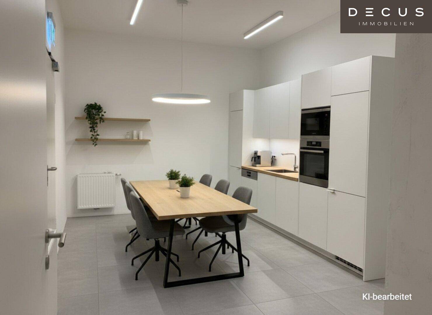 Moderne Küche mit integrierten Geräten und Essbereich, ideal für Besprechungen oder Mahlzeiten.