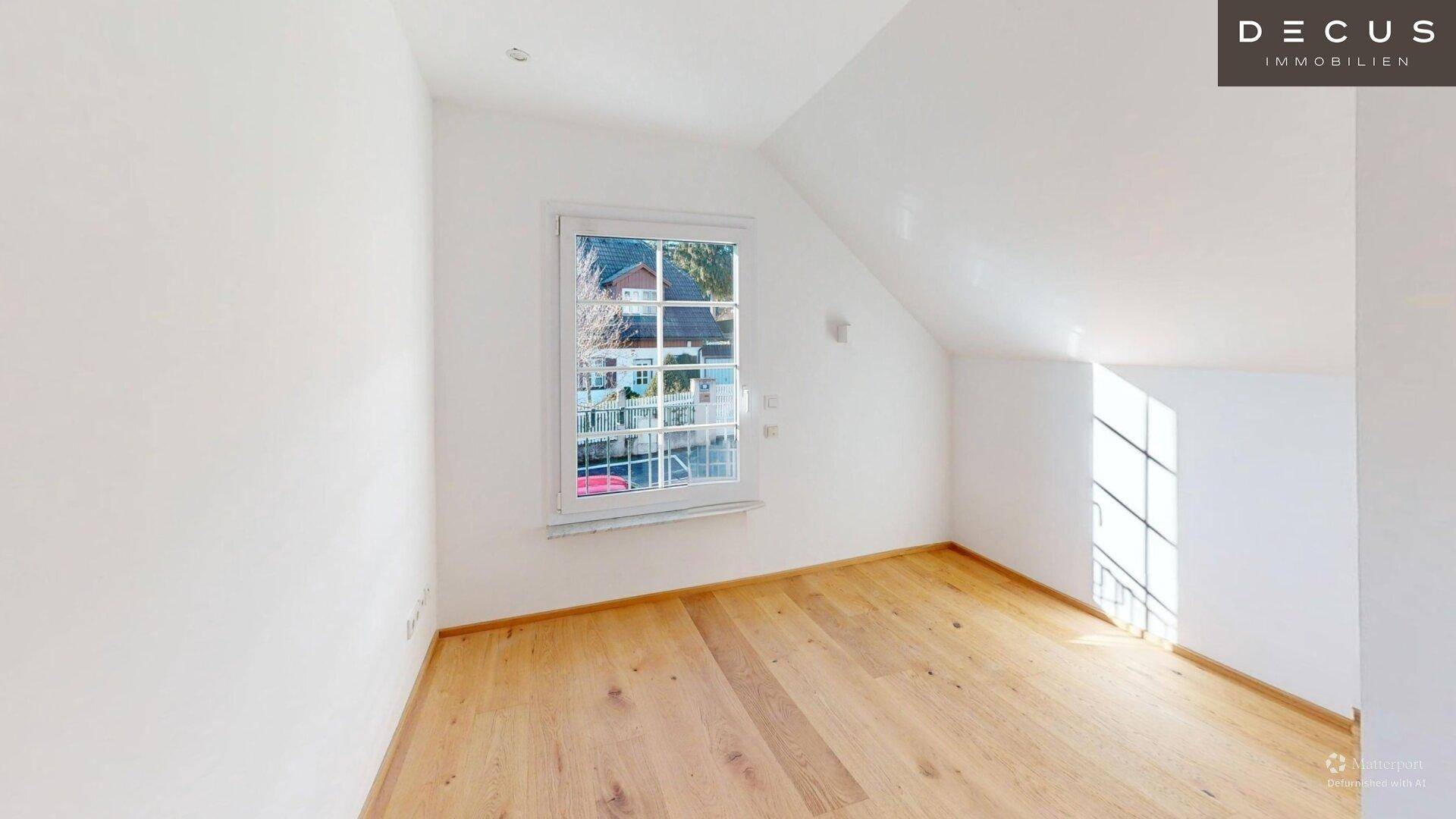 Helles Zimmer im Dachgeschoss mit Holzboden und Fenster, ideal als Schlaf- oder Arbeitszimmer.
