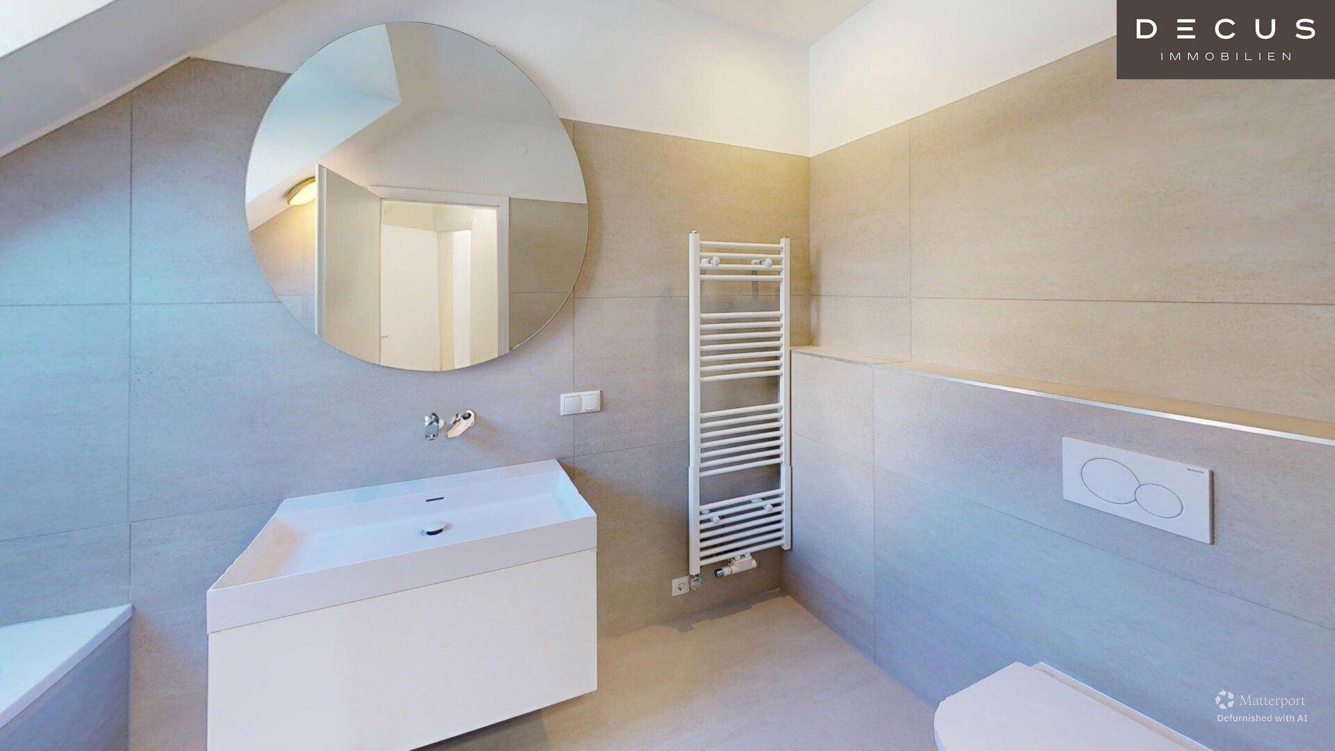 Modernes Badezimmer mit großem runden Spiegel, Einzelwaschbecken und beheiztem Handtuchhalter.