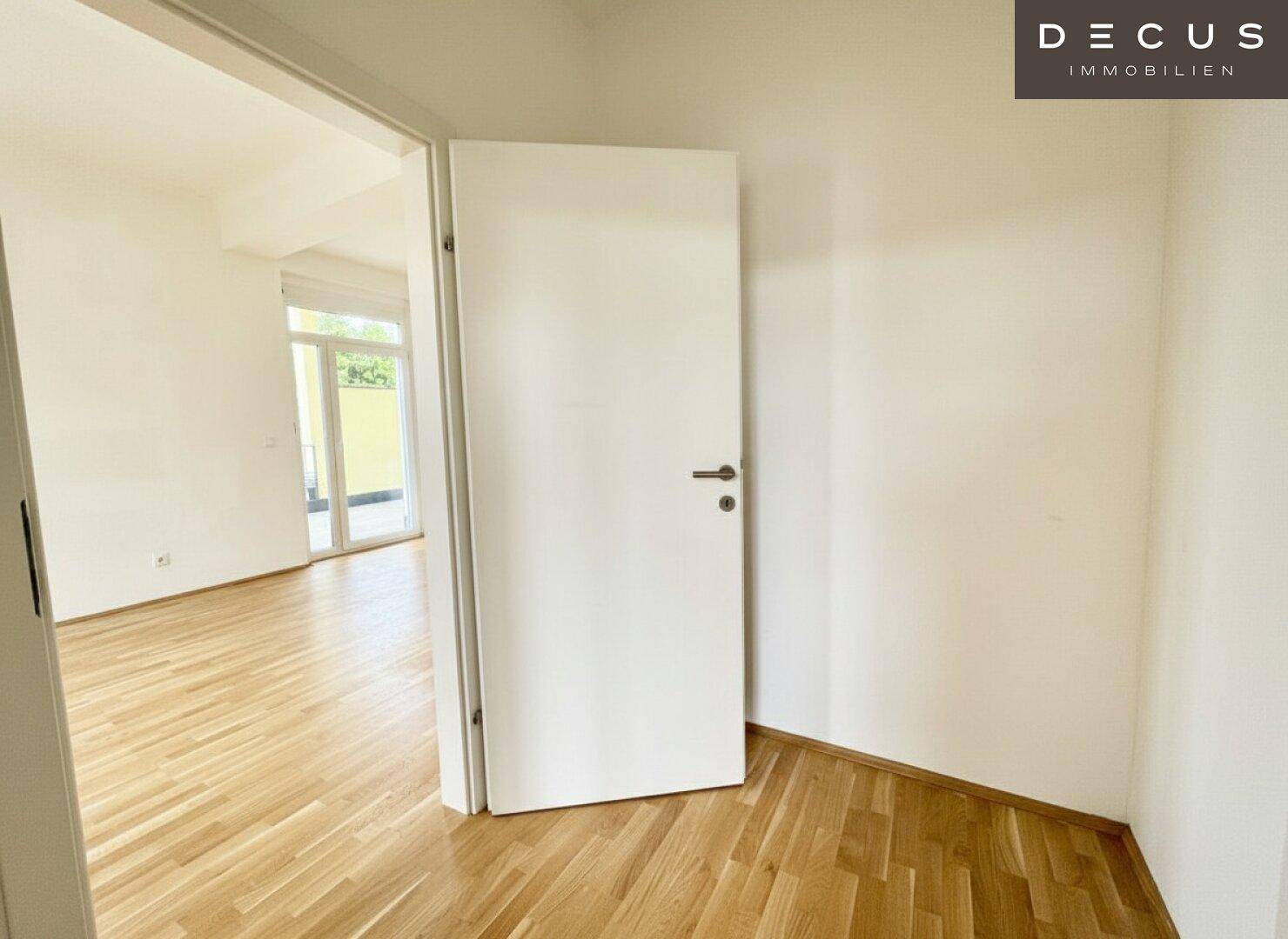 Heller Flur mit Holzboden und Zugang zu weiteren Räumen.
