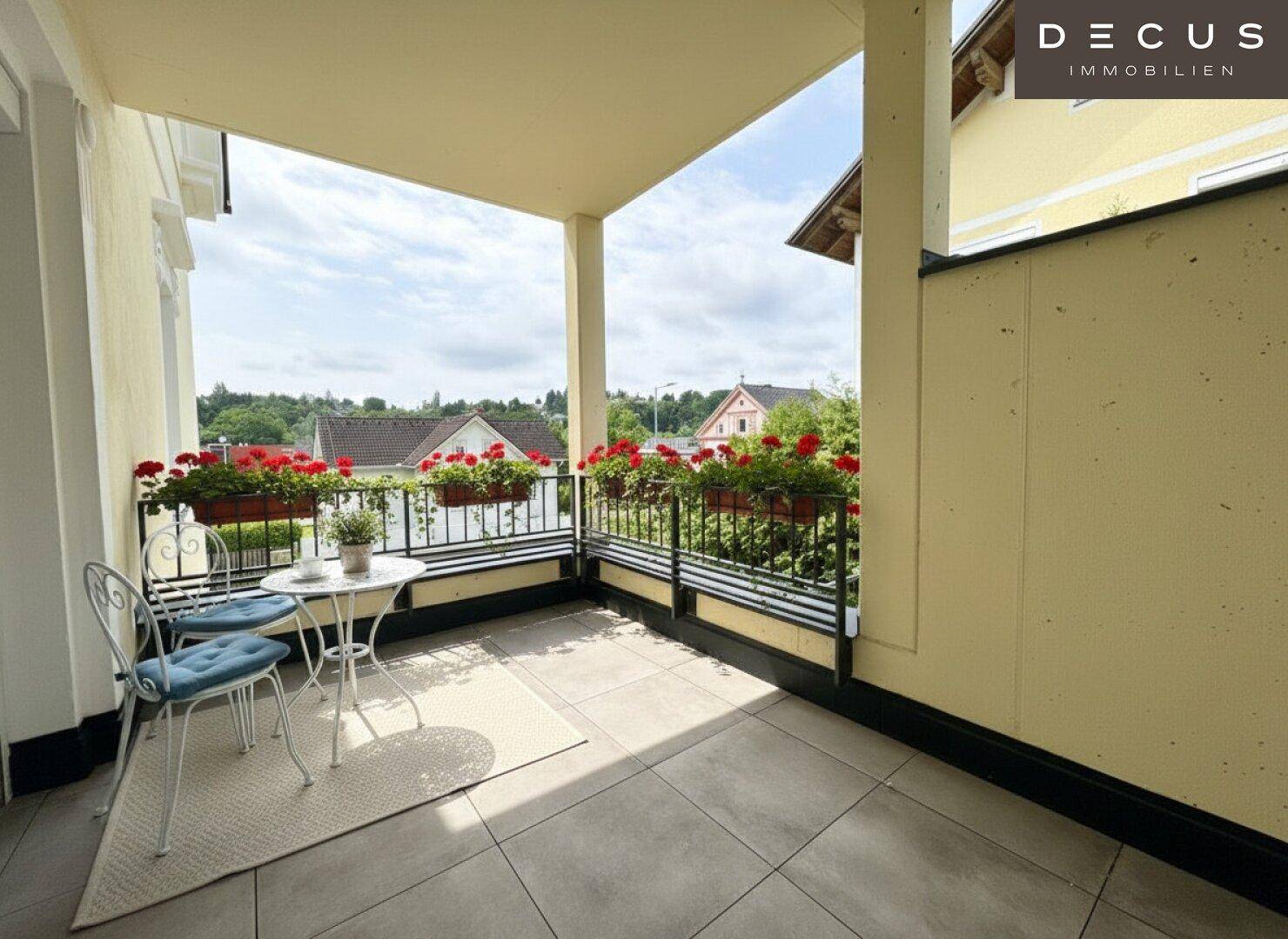 Geräumiger Balkon mit Fliesenboden, Blumenkästen und Blick auf die Nachbarschaft.