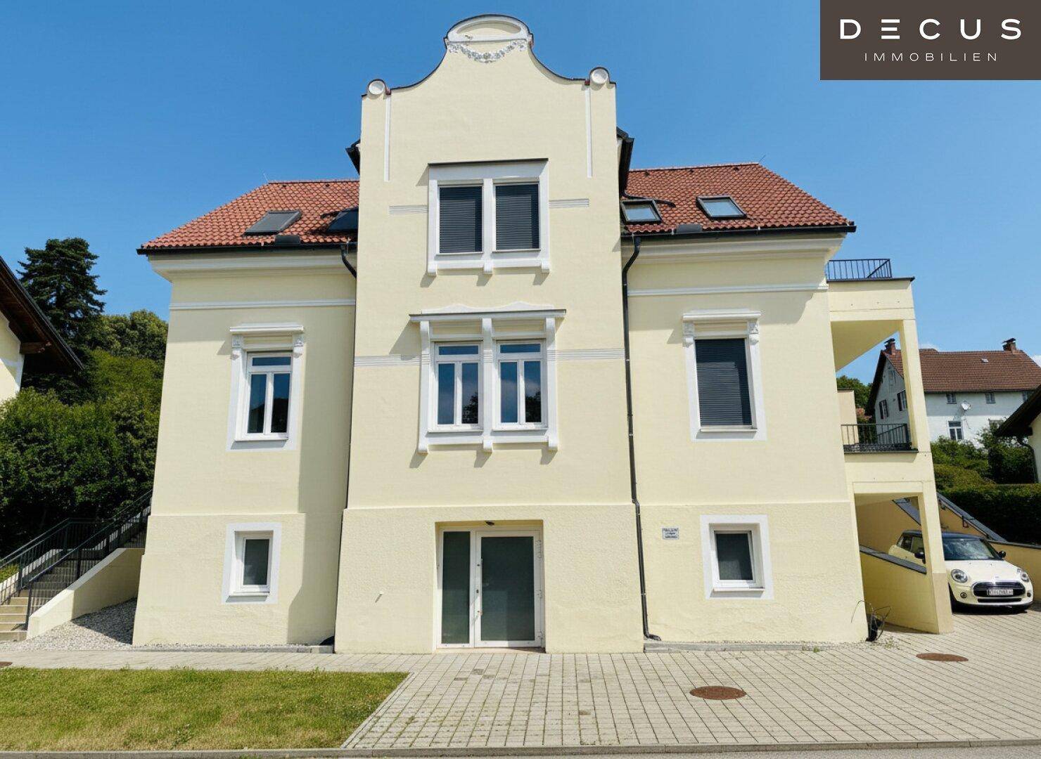 Historisches Gebäude mit gelber Fassade, roten Dachziegeln und klassischer Architektur.