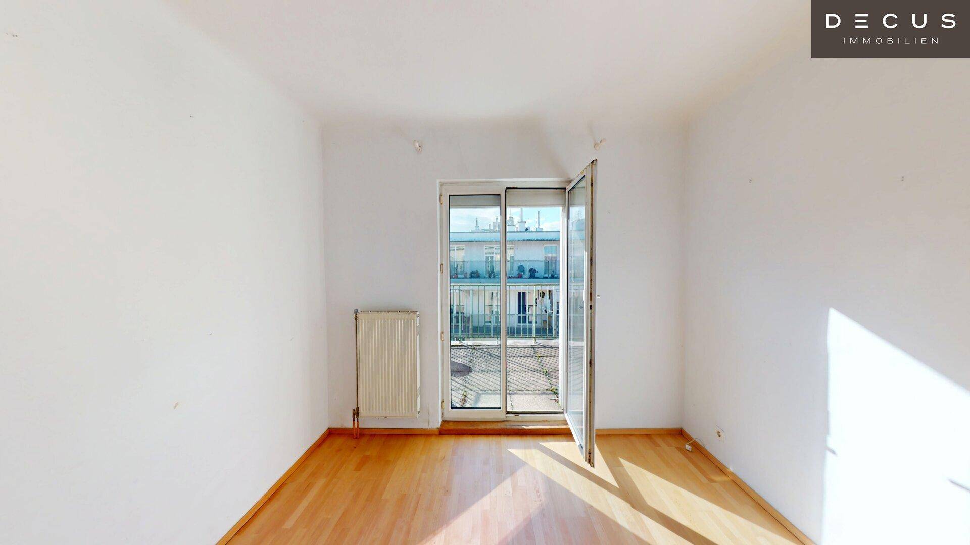 Heller Raum mit Parkettboden und Zugang zu einem Balkon, ideal für individuelle Gestaltung.