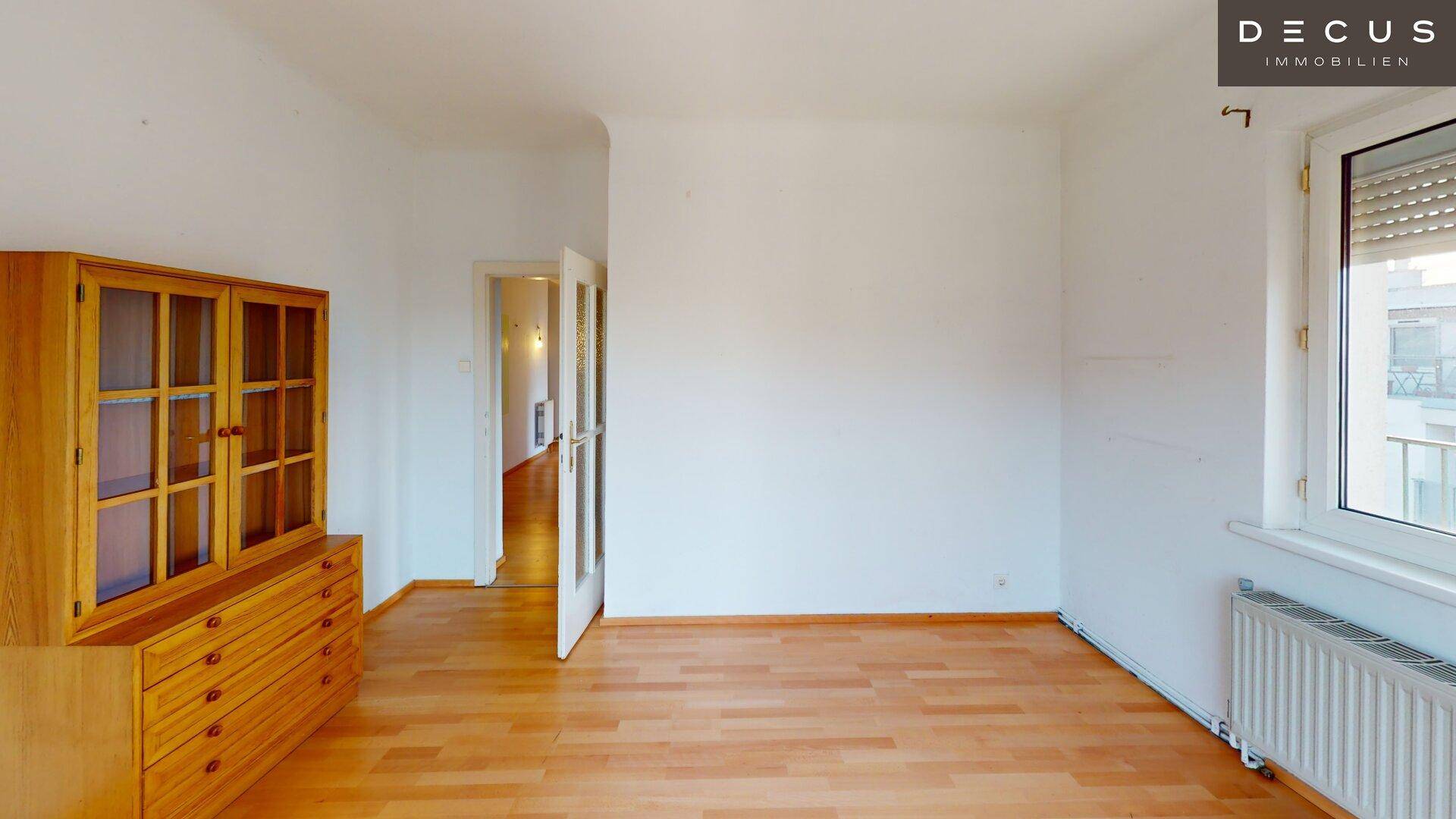 Heller Raum mit Parkettboden und einem Holzschrank, bietet vielseitige Nutzungsmöglichkeiten.