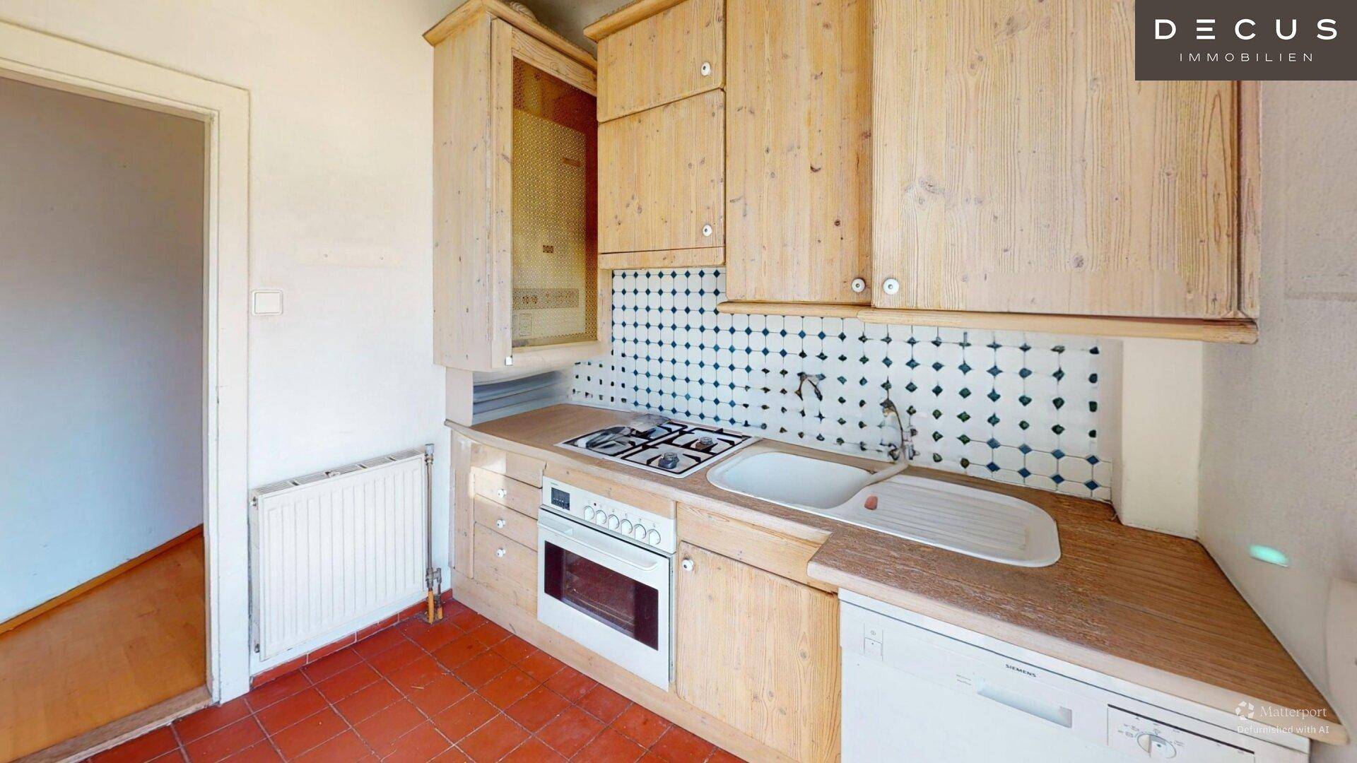 Küche mit Holzfronten, Gasherd und Terrakotta-Fliesenboden, bereit zur Nutzung.