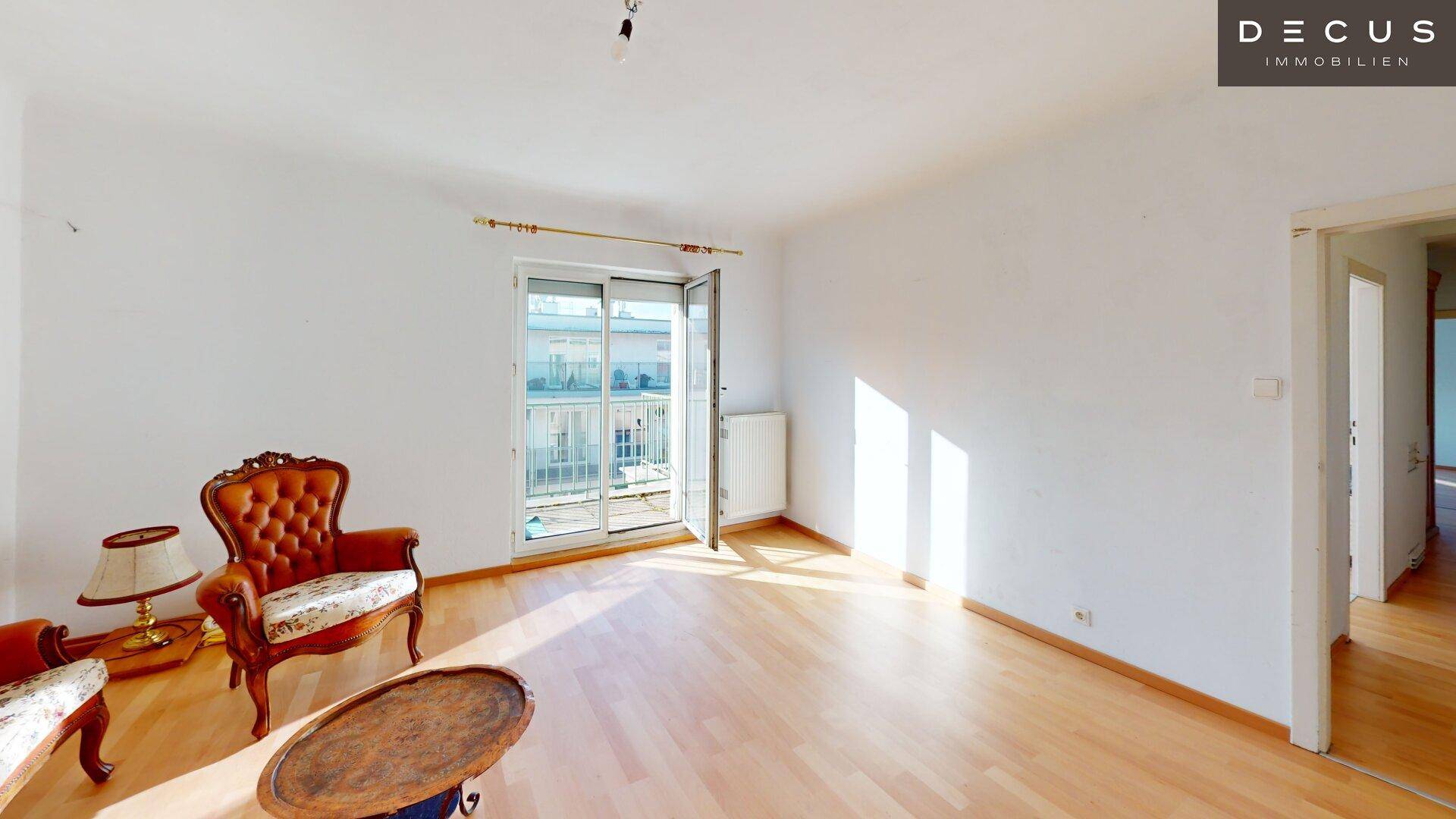 Helles Wohnzimmer mit Parkettboden und direktem Zugang zu einem sonnigen Balkon.