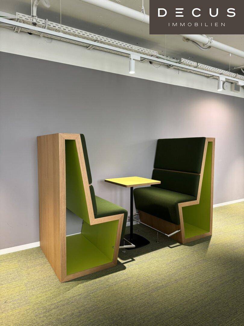 Gemütliche Besprechungsnischen mit gepolsterten Sitzen und einem kleinen Tisch in einem modernen Büro.