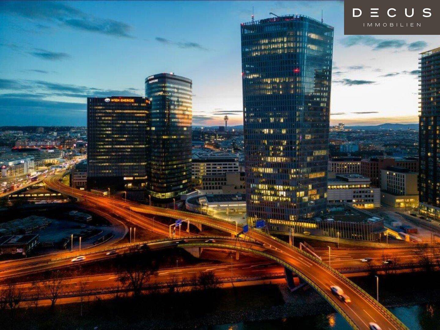 Beeindruckende Skyline bei Sonnenuntergang mit beleuchteten Hochhäusern und einer belebten Brücke.