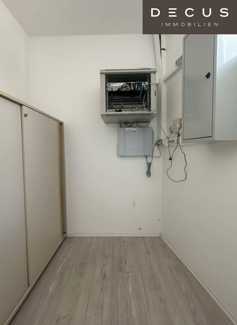 Kleiner Abstellraum oder Technikraum mit Laminatboden und an der Wand montierter Elektronik.
