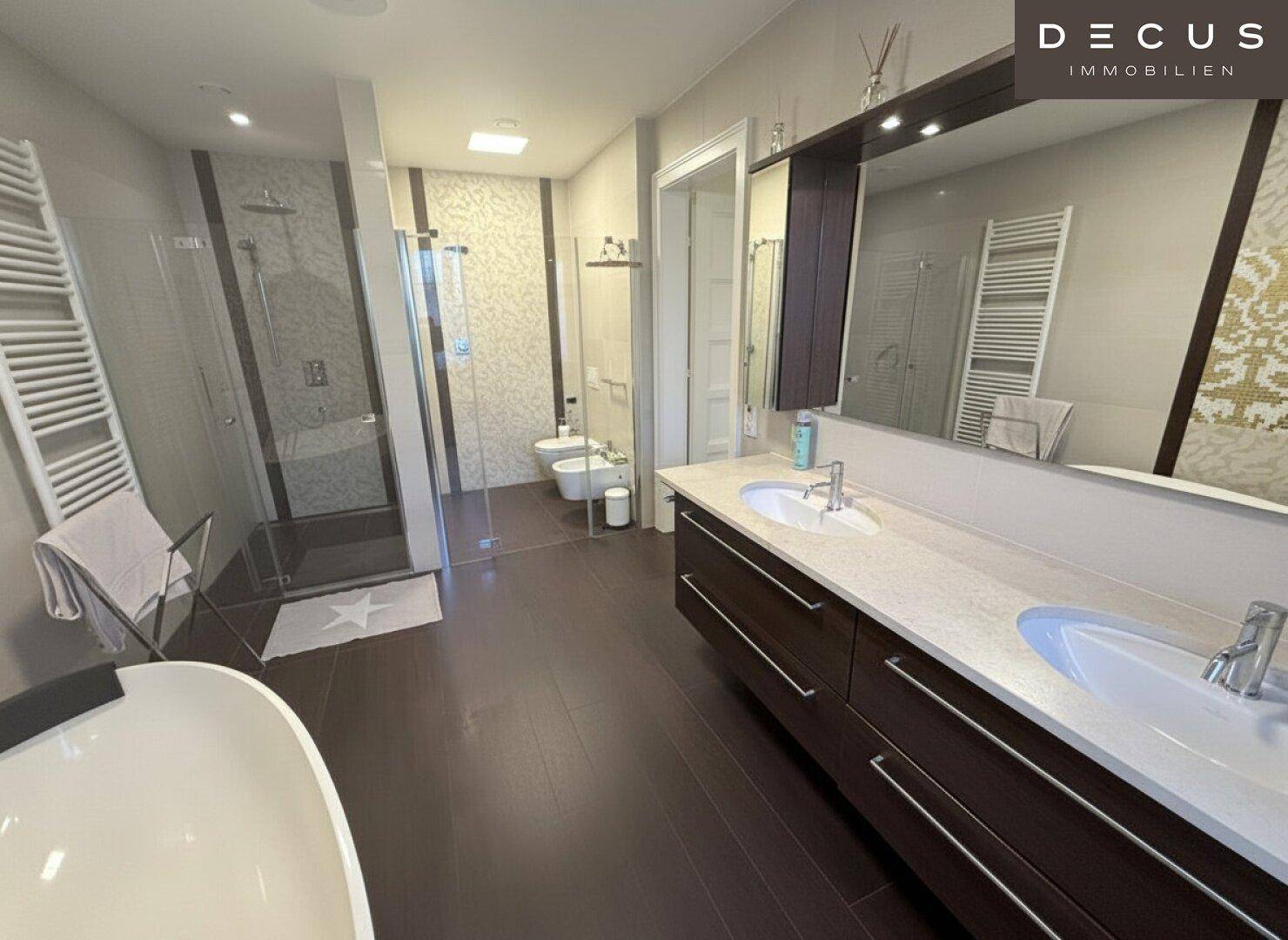 Modernes Badezimmer mit Doppelwaschbecken, begehbarer Dusche und freistehender Badewanne.