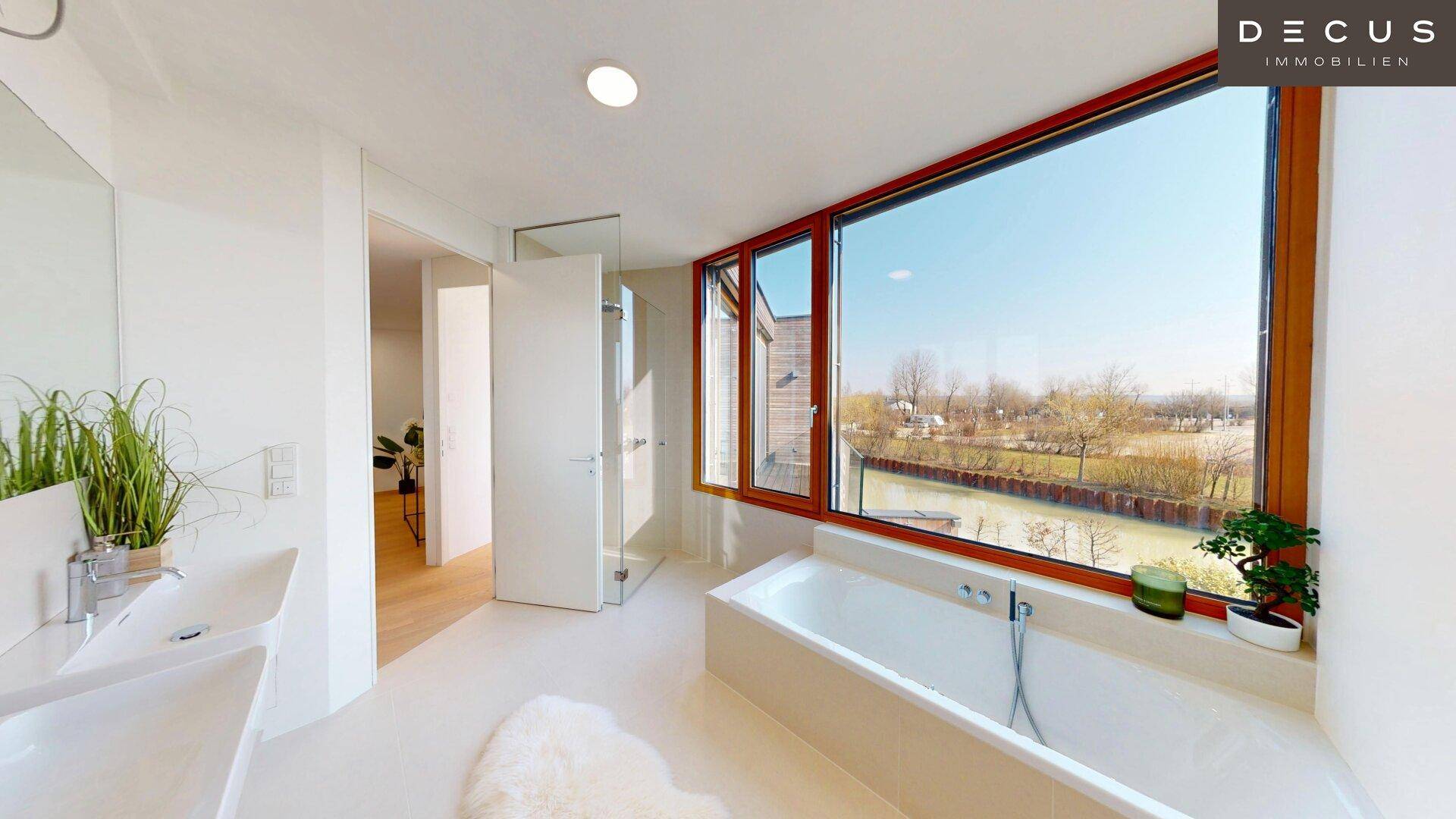 Modernes Badezimmer mit Badewanne, Doppelwaschbecken und großem Fenster mit Wasserblick.