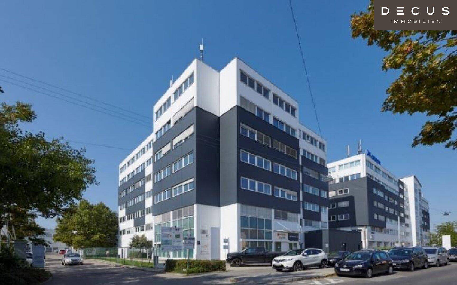 Ansicht eines modernen Bürokomplexes mit weißer und dunkelblauer Fassade unter blauem Himmel.