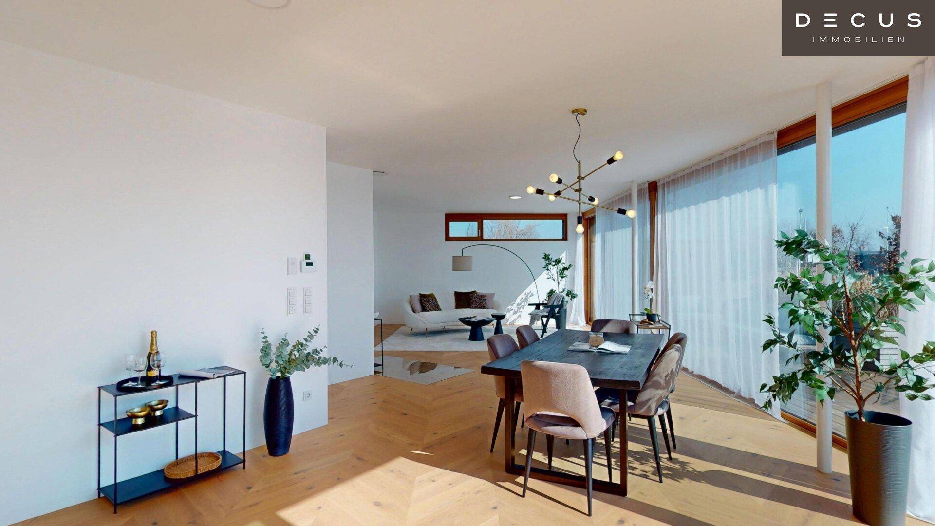 Eleganter Essbereich mit modernem Kronleuchter und Blick auf den See durch große Fenster.