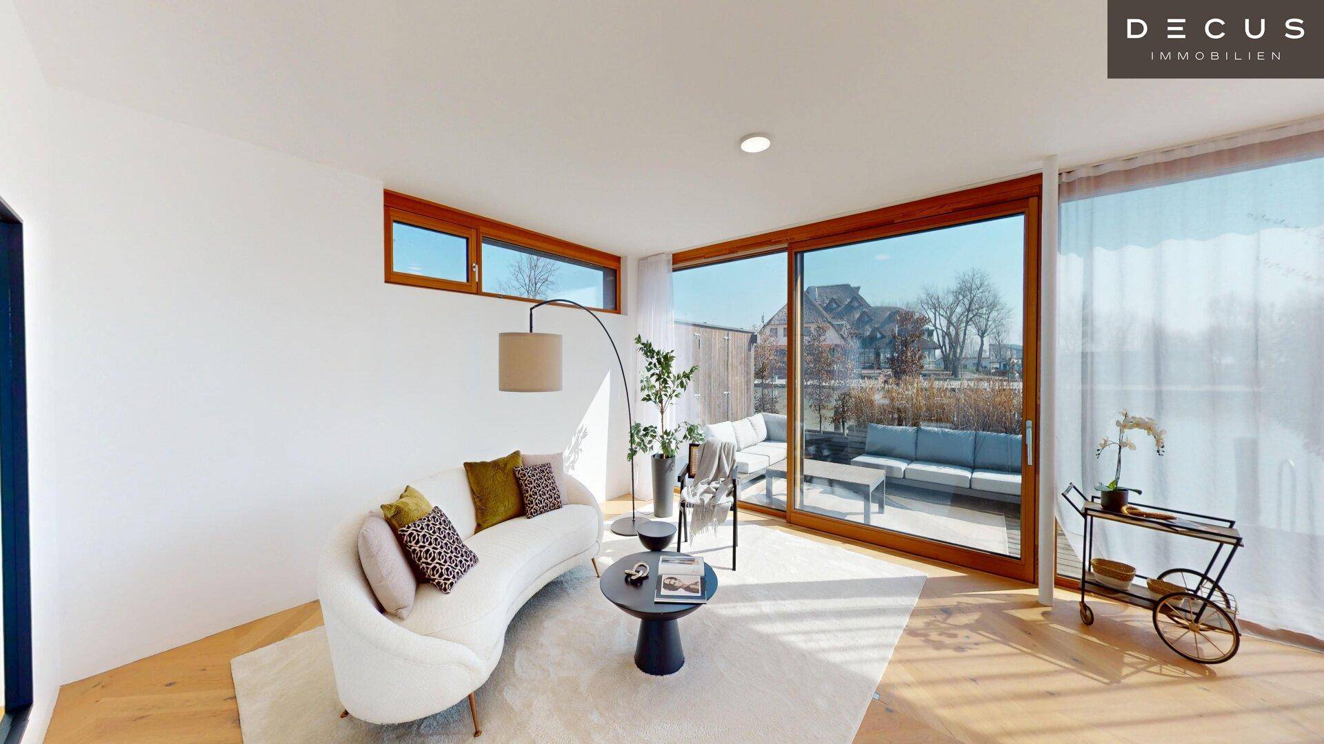 Gemütliches Wohnzimmer mit moderner Einrichtung, großen Fenstern und Zugang zur Terrasse.