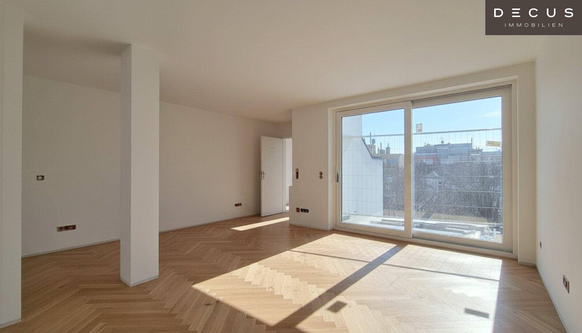 Geräumiges, leeres Wohnzimmer mit Fischgrätparkett und großen Fenstern, die viel Licht hereinlassen.