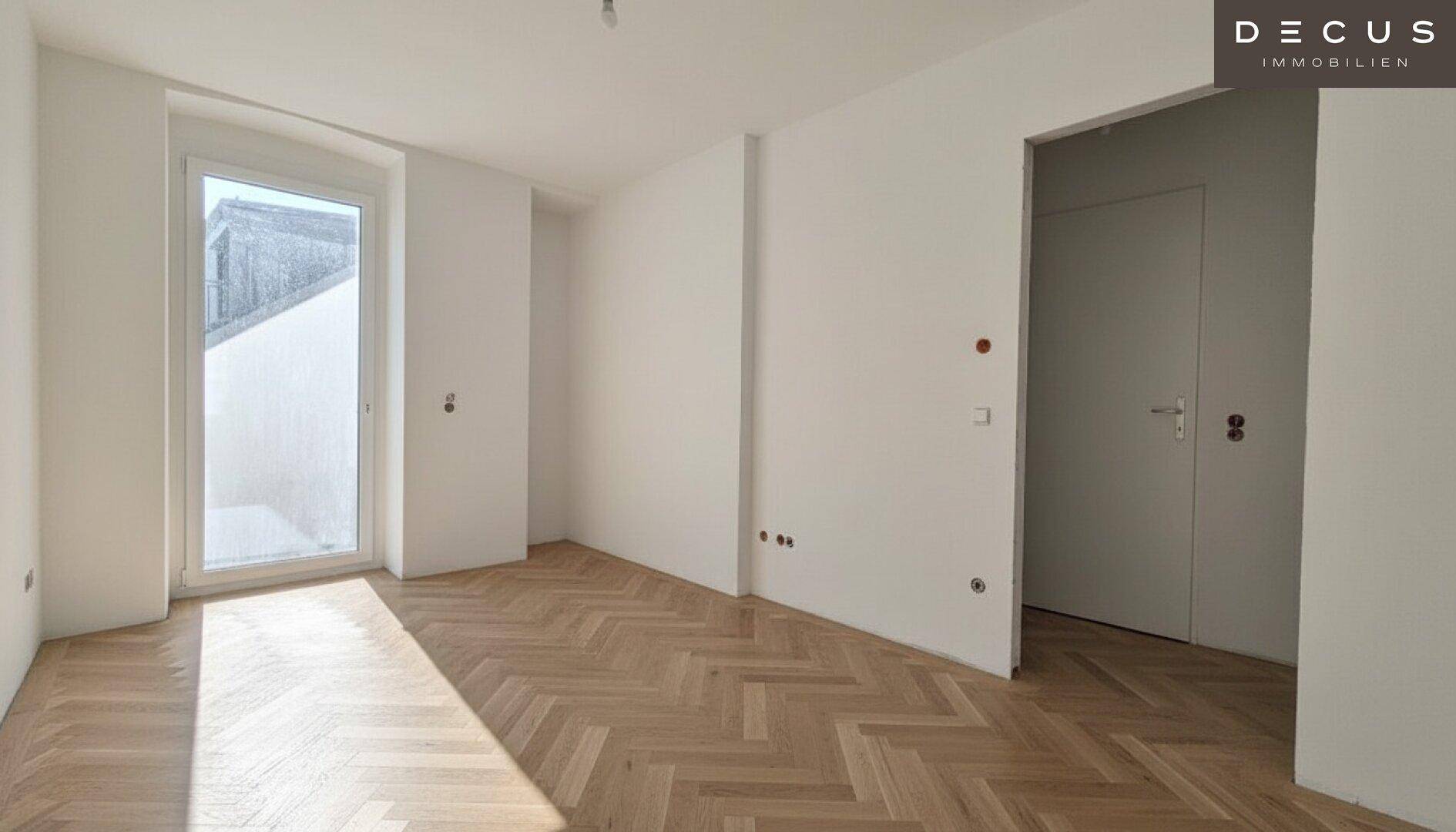 Leerer Raum mit Fischgrätparkett und einer Tür, die zu einem Balkon oder einer Terrasse führt.