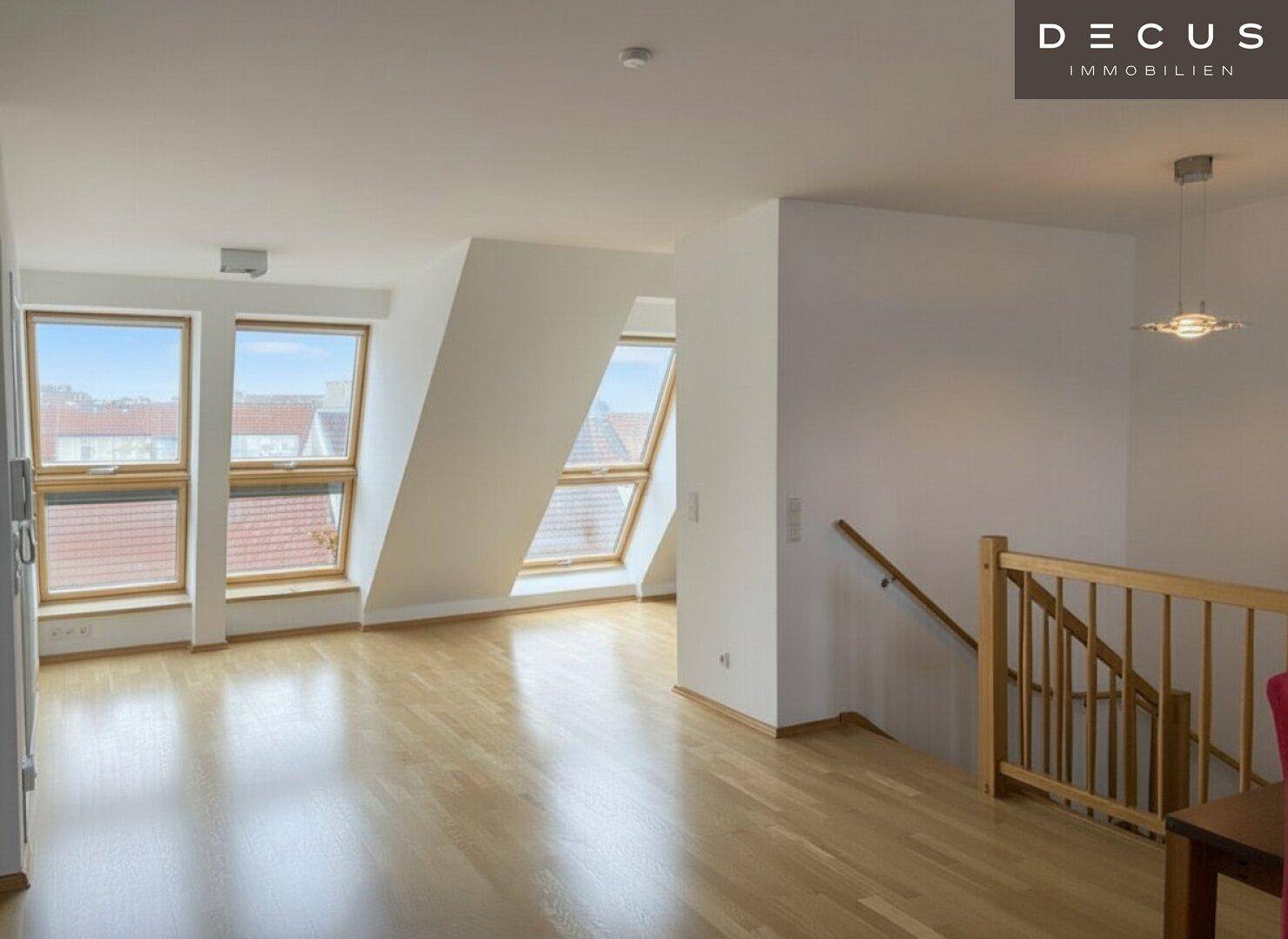 Geräumiger Dachbodenraum mit Holzboden und mehreren Dachfenstern, die viel Licht hereinlassen.