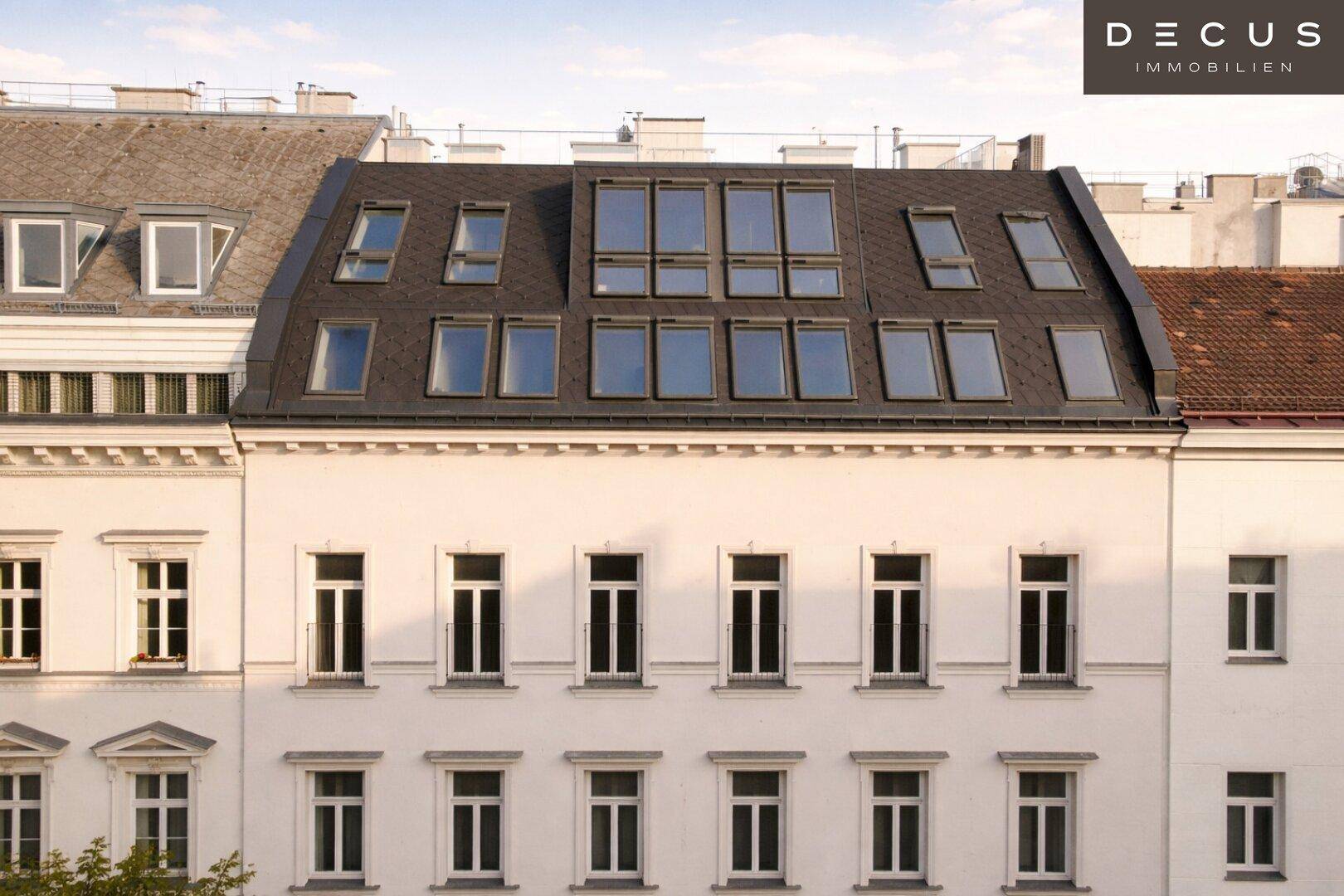 Dachgeschossausbau eines historischen Gebäudes mit zahlreichen Dachfenstern und moderner Dachkonstruktion.