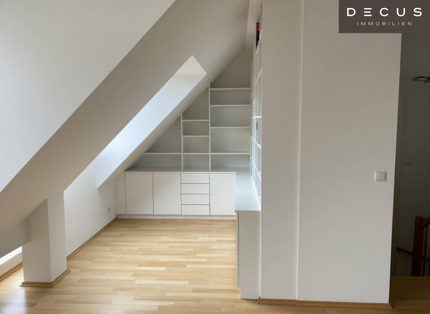 Dachbodenraum mit Holzboden und maßgefertigten Einbauschränken unter der Dachschräge, bietet viel Stauraum.