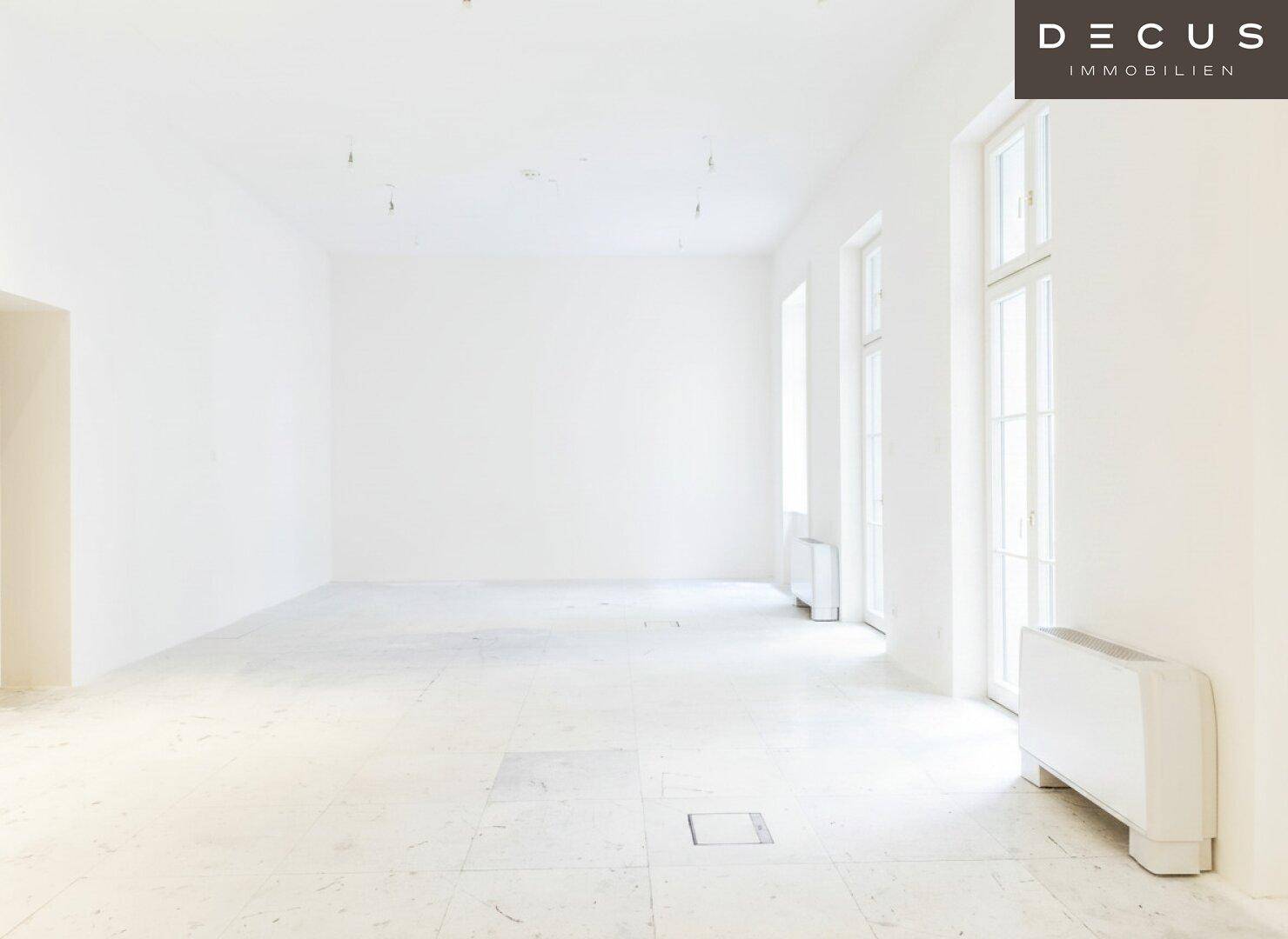 Heller, leerer Raum mit großen Fenstern und Heizkörpern unter den Fensterbänken, bereit zur Gestaltung.