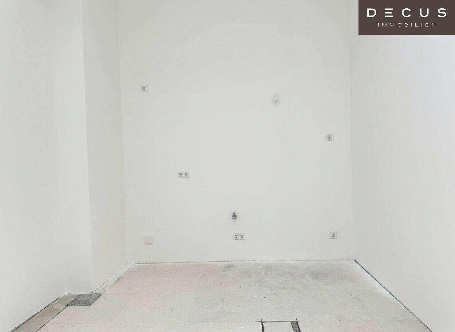 Kleiner, leerer Raum mit vielen Steckdosen und Anschlüssen an den Wänden, funktional und schlicht.