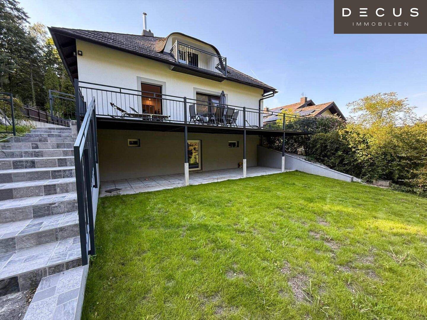 Großzügiger Gartenbereich mit Rasenfläche und Außentreppe zur Terrasse.