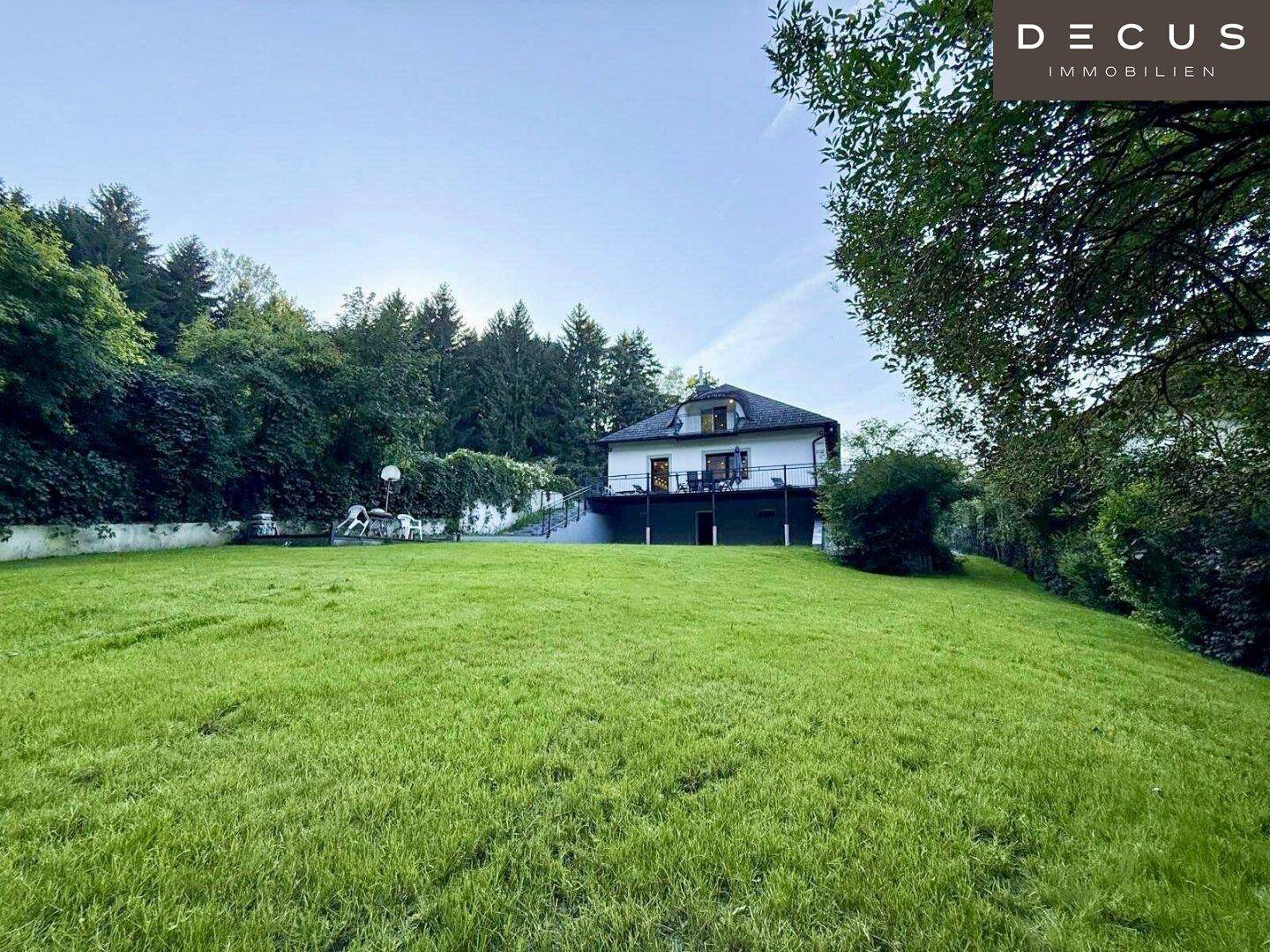 Freistehendes Haus umgeben von einem weitläufigen grünen Garten und Bäumen.