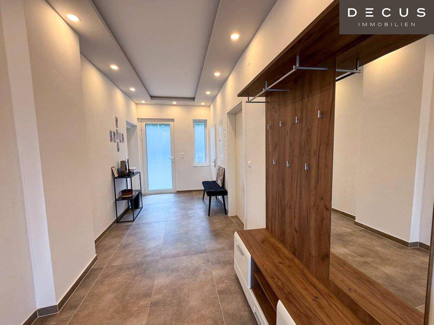 Moderner Eingangsbereich mit Fliesenboden und integrierter Garderobe.