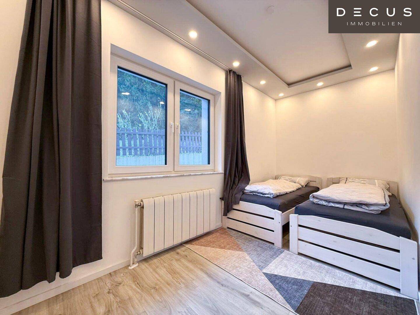 Gemütliches Schlafzimmer mit zwei Einzelbetten und Blick ins Grüne.
