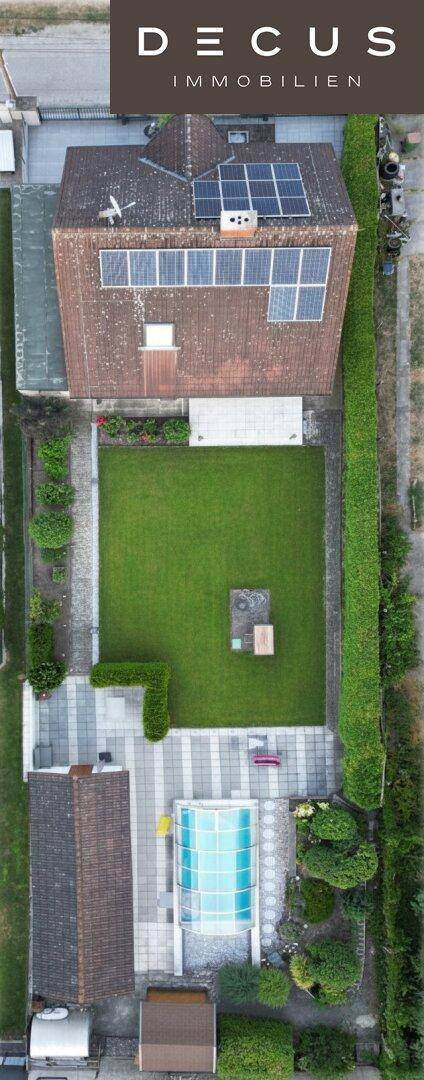 Vogelperspektive des Anwesens mit Haus, großem Garten, Pool und umlaufenden Hecken.