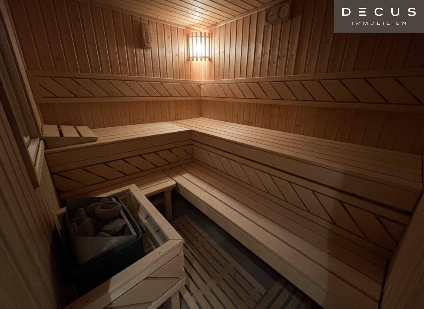 Innenansicht der Holzsauna mit mehreren Sitzebenen und traditionellem Saunaofen.