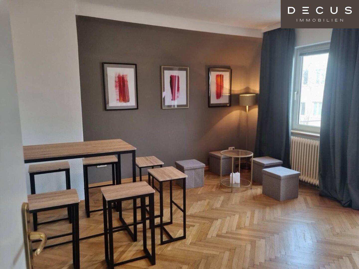 Vielseitiger Raum mit Bartisch, Hockern und Sitzgelegenheiten, ausgestattet mit Fischgrätparkett.